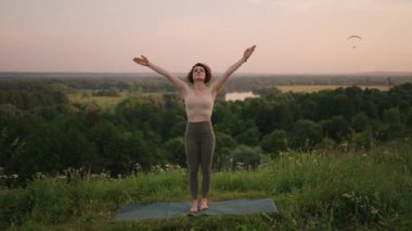 Yoga yapan genç bir kadın. Genç kadın pozisyonu, dışarıda meditasyon yapmaktan hoşlanıyor.