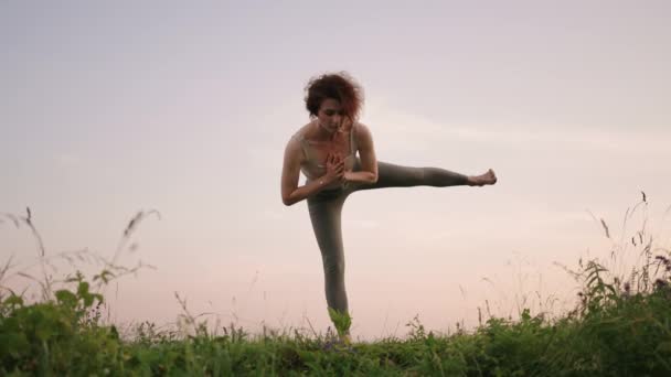 En yogamästare gör övningar för balans och stretching. Friden och smidigheten i rörelserna hos en flicka som gör yoga i bergen i skogen — Stockvideo