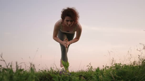 Mladá žena dělá jógu cvičení stojí na vrcholu lesní hory na pozadí řeky a lesní krajiny. Rovnováha těla a ducha, relaxace a meditace — Stock video