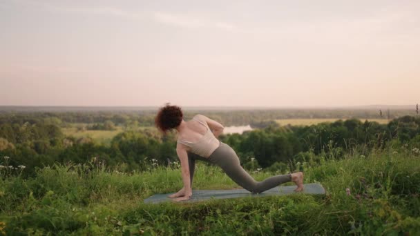 Mistr jógy provádí různá cvičení a pohyby pro rovnováhu a rozvoj duše, zatímco stojí v lesních horách brzy ráno ve zpomaleném filmu — Stock video