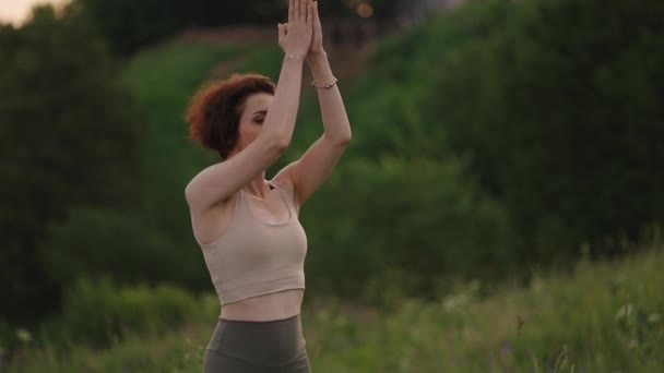 Žena cvičí jógu za úsvitu v borovém lese. Silueta mladé duchovní dívky medituje v lotosu představovat přírodu venku, zpomalený pohyb. Koncept fitness, zdravého životního stylu — Stock video