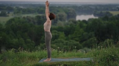 Yoga ustası denge ve ruh gelişimi için çeşitli egzersizler ve hareketler yapar. Sabahın erken saatlerinde ormanın dağlarında ağır çekimde ayakta durur.