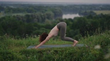 Yoga yapan genç bir kadın. Genç kadın pozisyonu, dışarıda meditasyon yapmaktan hoşlanıyor.
