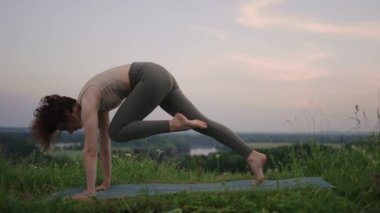 Yoga yapan genç bir kadın. Genç kadın pozisyonu, dışarıda meditasyon yapmaktan hoşlanıyor.