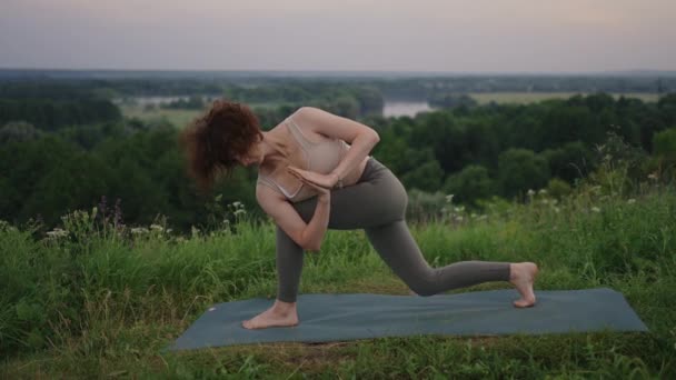Linda chica haciendo yoga y pilates en el bosque de montaña. Chica fitness entrenamiento al aire libre en el paisaje de la naturaleza. — Vídeo de stock