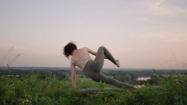 A yoga master does exercises for balance and stretching. The peace and smoothness of the movements of a girl doing yoga in the mountains in the forest — Stock Video