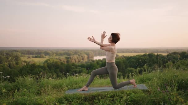 瑜伽大师在清晨慢条斯理地站在森林群山中进行各种运动，以促进身心平衡与发展 — 图库视频影像