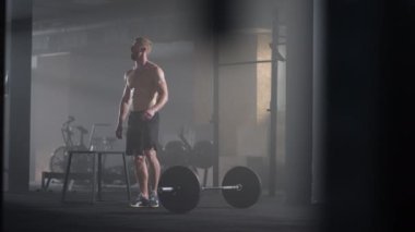 Spor salonundaki yoğun egzersizden sonra yorgun gençler dinleniyor. Spor salonundaki antrenmandan sonra yorgun ve sağlıklı bir adam. Yorgun erkek model, yoğun egzersizden sonra ayakta duruyor ve dinleniyor..