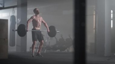 Ağır çekimde: Zalim sporcu çıtayı kendi üzerine kaldırır, bir pislik gibi davranır, dönen bir itiş. Bir adam karanlık bir arkaplanda halter kaldırmakla meşgul. Portre. Güç kavramı, güç, spor yapmak..