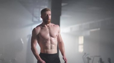 Egzersiz yaptıktan sonra spor salonunda antrenman yaparak yorgun düşen bir sporcu dinlenir ve güç kazanır. Yoğun ve güçlü bir adam antrenman sırasında iyileşir.