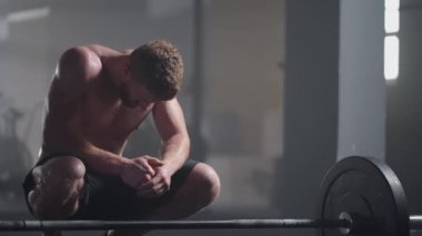 Güzel atletik adam alnından terini eliyle siliyor ve kameraya bakıyor. Yoğun Çapraz Vücut Egzersizinden Yorgun