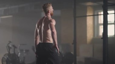 Güzel atletik adam alnından terini eliyle siliyor ve kameraya bakıyor. Yoğun Çapraz Vücut Egzersizinden Yorgun