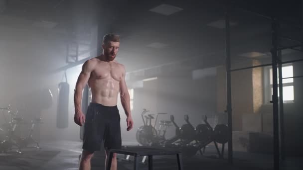 Atleet gaf oefening. Springen op de doos. Sterke mannelijke atleet springen op kubus close-up. Tracking shot van fit sportvrouw springen op kubus tijdens intense crossfit training in de sportschool — Stockvideo