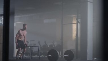 Sporcu egzersiz yaptı. Kutunun üstüne atlamak. Küp 'e atlayan güçlü bir erkek atlet. Spor salonundaki yoğun idman sırasında formda bir sporcunun kübün üzerine atlaması.