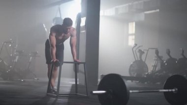 Egzersiz yaptıktan sonra spor salonunda antrenman yaparak yorgun düşen bir sporcu dinlenir ve güç kazanır. Yoğun ve güçlü bir adam antrenman sırasında iyileşir.