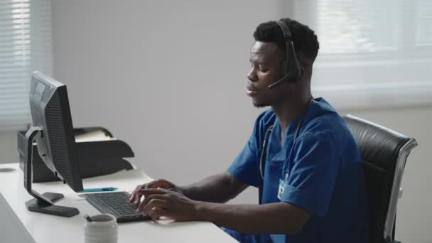 Consulta Médica Online: Médico Afro-Americano Fazendo uma Chamada de Vídeo em Conferência com um Paciente em um Computador Desktop. — Vídeo de Stock