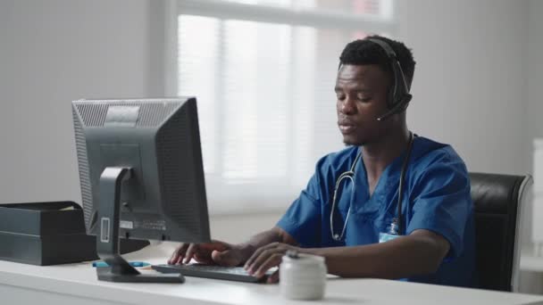 Läkare Online medicinsk konsultation: afroamerikansk läkare gör en konferens Video samtal med en patient på en stationär dator. — Stockvideo