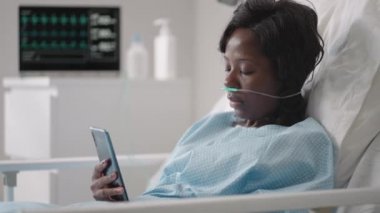 Genç bir kadın hastane koğuşunda yatarken telefonuna bir mesaj yazıyor. Afrikalı bir kız ECG ve oksijen cihazlarına bağlı bir koğuşta yatıyor ve akrabalarına mesajlar yazıyor.
