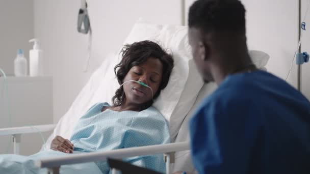 Un jeune médecin afro-américain parle à un patient. Une patiente noire parle à un médecin — Video