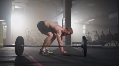 Spor salonunda burpee egzersizi yapan fitness adamı. Genç bir adamın şınav çekerken ve ağır çekimde zıplama egzersizi yaparken orta boy bir fotoğraf. Spor konsepti