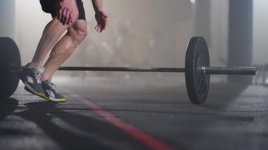 Spor salonunda burpee egzersizi yapan fitness adamı. Genç bir adamın şınav çekerken ve ağır çekimde zıplama egzersizi yaparken orta boy bir fotoğraf. Spor konsepti