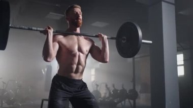 Ağır çekim: Adam spor salonunda kaldırma egzersizi yapıyor.