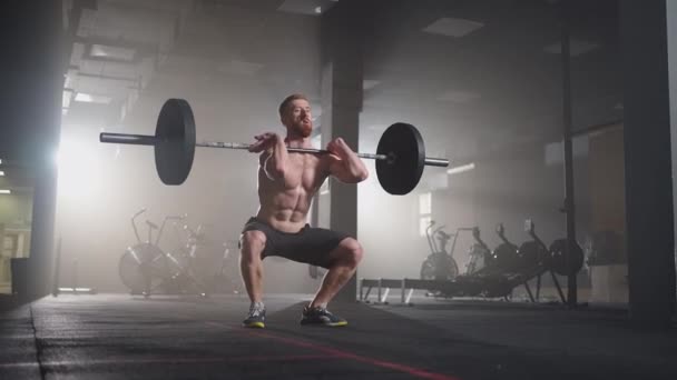 Athletic Beautiful man Does Overhead Deadlift with a Barbell in the Gym. Ejercicios profesionales masculinos magníficos del levantamiento de pesas del entrenamiento del culturista en el centro de entrenamiento auténtico del ajuste — Vídeo de stock