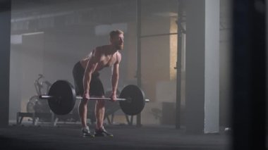 Ağır çekim: Erkek kaldırıcı beden eğitimi için hazırlanıyor. Çığlık atan adam ağırlık kaldırıyor.