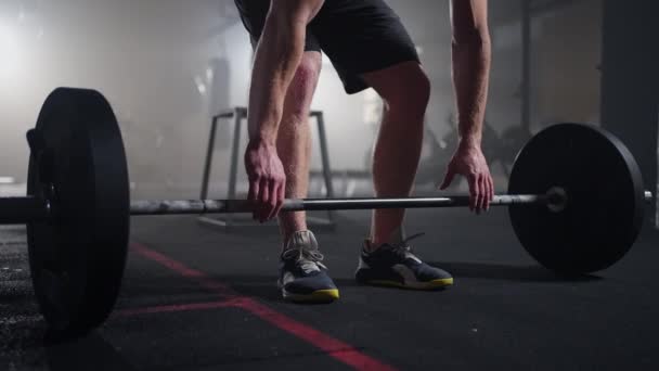 Cámara lenta: levantador de pesas masculino que se prepara para el entrenamiento en el gimnasio. Hombre gritando levantando pesas — Vídeos de Stock