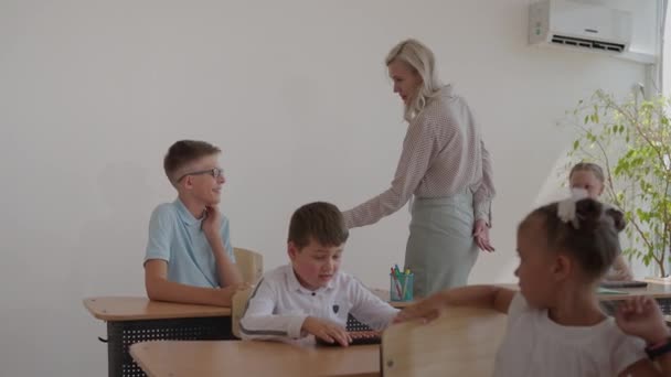 El maestro choca los cinco años con el niño en el aula durante la lección. — Vídeo de stock