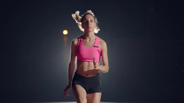 Una joven está sola en el estadio de atletismo y se prepara para la carrera. Preparación para el sprint. Concentración y preparación psicológica para competiciones en cámara lenta — Vídeo de stock