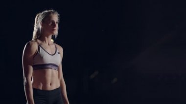 Genç bir kız hipodrom ve stadyumda tek başına duruyor ve yarış için hazırlanıyor. Sürat koşusu için hazırlık. Ağır çekimde yarışmalar için konsantrasyon ve psikolojik hazırlık