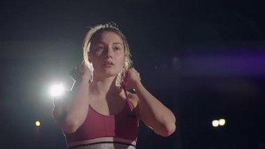 Ağır çekimde koşan kadın yarış için hazırlanıyor. Yarışmadan önce konsantrasyon ve ısınma. Psikolojik istikrar ve bir kadın sporcunun azmi