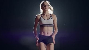 Genç bir kız hipodrom ve stadyumda tek başına duruyor ve yarış için hazırlanıyor. Sürat koşusu için hazırlık. Ağır çekimde yarışmalar için konsantrasyon ve psikolojik hazırlık