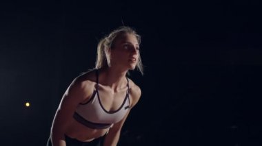 Genç bir kız hipodrom ve stadyumda tek başına duruyor ve yarış için hazırlanıyor. Sürat koşusu için hazırlık. Ağır çekimde yarışmalar için konsantrasyon ve psikolojik hazırlık