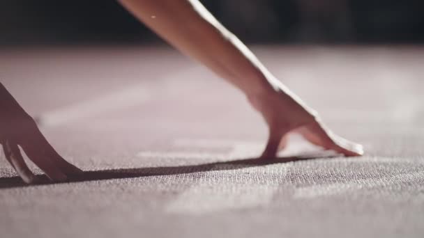 Bir kadın, yarışın başlangıcında başlangıç pozisyonunda çömelirken el pençe divan durur. Dişi sporcu hazırlan ve başla. Koşucu eller başlangıç çizgisinde bekliyor, yerde başlangıç çizgisinin önünde.. — Stok video