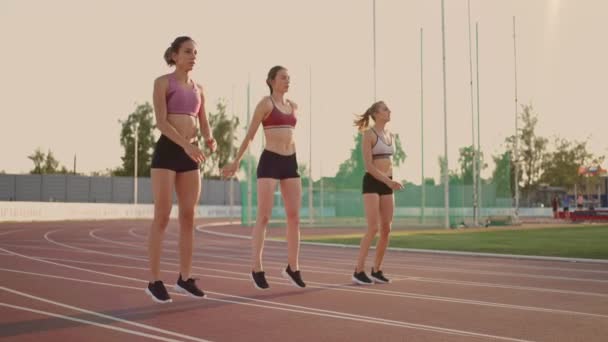 Skupina žen na dostihové a terénní soutěži se zahřívá a připravuje na závod. Soustředit se na startovní čáru na stadionu — Stock video