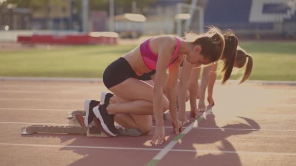 Trois athlètes féminines commencent simultanément à courir marathon, rivalité, ralenti. femmes debout sur une ligne de départ avant la course — Video