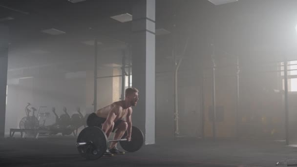 Cámara lenta: hombre haciendo ejercicio de elevación mortal en el gimnasio — Vídeo de stock