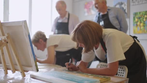 Gelukkig groepje senioren schetsen samen plaatjes in de klas. — Stockvideo