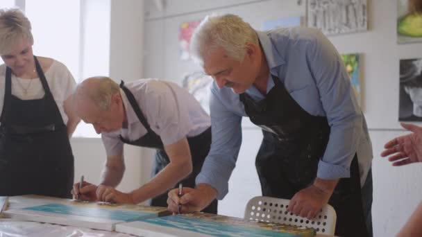 Happy group of senior people paint pictures together in class. — Stock Video