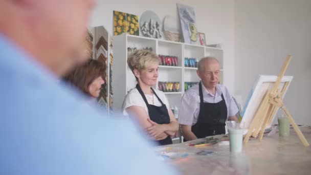 Elderly men and women share their impressions of the drawing courses. Emotions of a senior people talking together. Activities for older friends — Stock Video