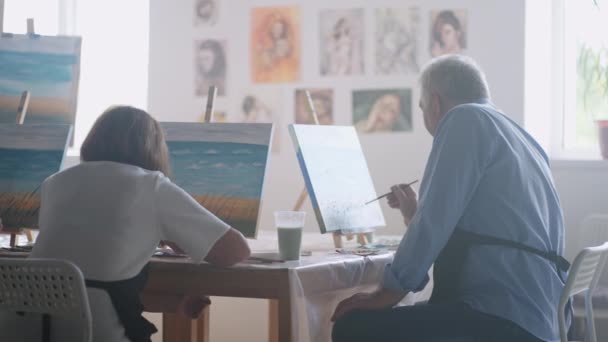 Senior man met vrienden tekent een tekening. De oude mannenclub heeft plezier en schildert samen.. — Stockvideo