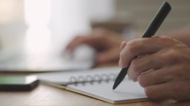 Elinde kalem tutan işadamı organizatör konsepti hakkında yeni atamalar yazıyor, karışık ırk erkek elleri masadaki kağıt planlayıcıya notlar yazıyor, hisse senedi ve yatırım piyasasını öğreniyor.