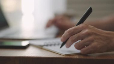 Elinde kalem tutan işadamı organizatör konsepti hakkında yeni atamalar yazıyor, karışık ırk erkek elleri masadaki kağıt planlayıcıya notlar yazıyor, hisse senedi ve yatırım piyasasını öğreniyor.