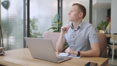 Erkek kolej öğrencisi dizüstü bilgisayar kullanarak uzaktan öğrenim semineri, uzaktan üniversite webinarı ya da üniversitenin yaratıcı alanında sanal sınıf toplantısı yapıyor..