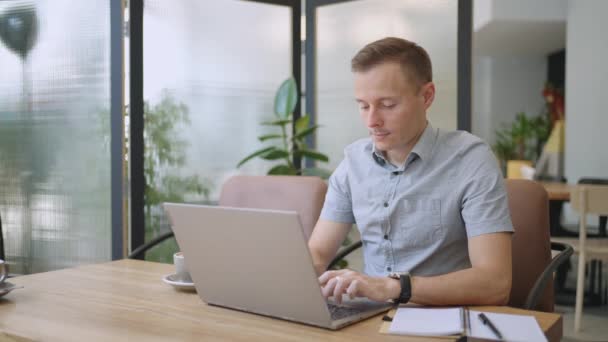 Mooie mannelijke ontwikkelaar of student aan het werk, studeren met laptop in cafe. freelance, werken op afstand, online onderwijs, zelfstandige — Stockvideo