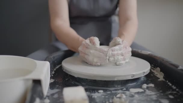 Oudere vrouw meester werkt op een pottenbakkerswiel en maakt een mok van keramiek in haar werkplaats in slow motion — Stockvideo