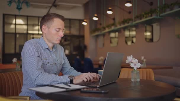 Bello sviluppatore maschio o studente che lavora, studiando dal computer portatile in caffè. freelance, lavoro a distanza, formazione online, lavoro autonomo — Video Stock