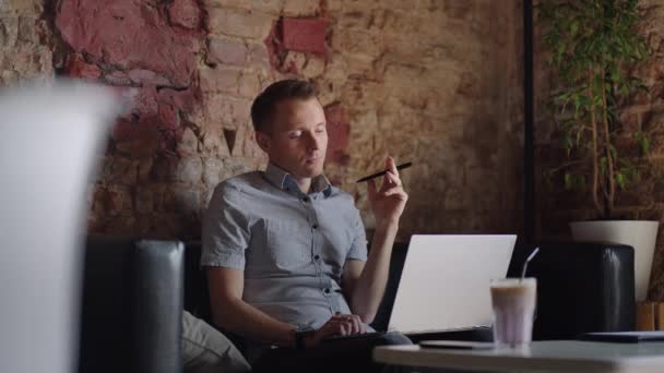 Продуманий серйозний молодий чоловік студент письменник сидить на домашньому офісному столі з ноутбуком, думаючи про натхнення пошук проблемних рішень ідеї втрачені в думках концепція мріяти озираючись — стокове відео